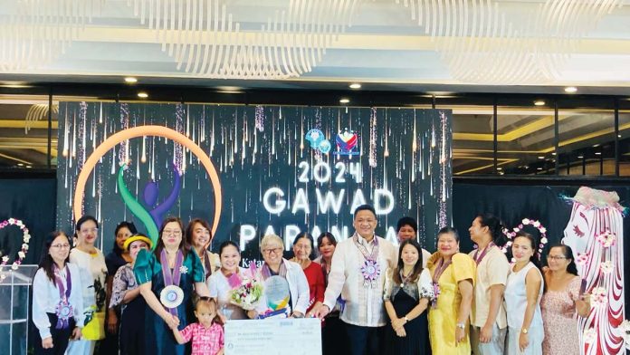 Ma. Ninfa Desiree Segovia of Tambisaan, Barangay Manoc-manoc, Malay, Aklan receives her P50,000 cash prize and a plaque of recognition as regional winner in the 2024 Search for Outstanding Rural Women (SORW) of the Department of Agriculture Region 6.