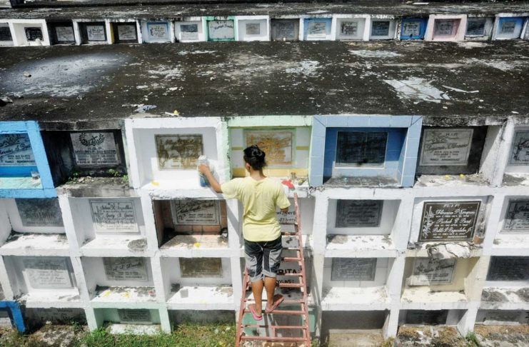 REMEMBERING DEPARTED LOVED ONES. It is a tradition for families to visit cemeteries on Nov. 1 and Nov. 2, bringing candles and flowers for their departed loved ones. Photo shows a man sprucing up tombs at the Jaro Catholic Cemetery in Iloilo City ahead of Fiesta Minatay. AJ PALCULLO/PN