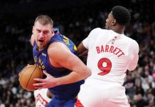 Denver Nuggets’ Nikola Jokic wards off the defense of Toronto Raptors' RJ Barrett. AP