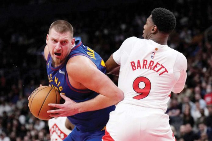 Denver Nuggets’ Nikola Jokic wards off the defense of Toronto Raptors' RJ Barrett. AP