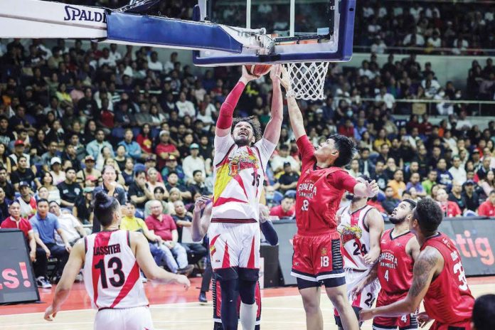 San Miguel Beermen’s June Mar Fajardo scores against the defense of Barangay Ginebra San Miguel Kings’ Ralph Cu. PBA PHOTO