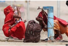 Two women drink water and splash their face from a public tap on a street in Prayagraj, India. This summer, India experienced its longest ever recorded heatwave, according to officials. AFP