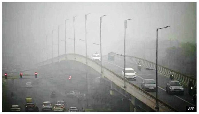 Commuters drive amid dense smog in New Delhi, India. AFP