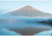 A wide shot of Mount Fuji seen without snow, silhouetted in a blue lake, in September last year. GETTY IMAGES