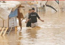 Men wade through murky floodwaters in southeastern Spain. More than a year’s worth of rain fell in just eight hours, local officials say. BBC