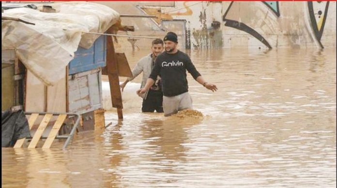 Men wade through murky floodwaters in southeastern Spain. More than a year’s worth of rain fell in just eight hours, local officials say. BBC