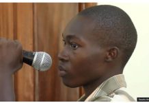 Emmanuel Nabugodi, Ugandan TikToker who has been jailed, holds a microphone in court. He created a mock trial of President Yoweri Museveni. SWAIBU IBRAHIM / BBC