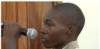 Emmanuel Nabugodi, Ugandan TikToker who has been jailed, holds a microphone in court. He created a mock trial of President Yoweri Museveni. SWAIBU IBRAHIM / BBC