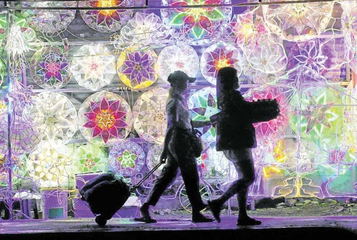 Pedestrians pass by colorful Christmas lanterns that have sprung up as the holidays approach. The season marked by heightened consumption will cause even more traffic in the metropolis. INQUIRER/GRIG C. MONTEGRANDE PHOTO