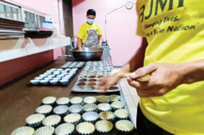 FRESHLY BAKED HOPE. Inmates at the Iloilo District Jail Male Dormitory in Barangay Nanga, Pototan, Iloilo are seen baking bread as part of their livelihood training. Warden Chief Inspector Mark Malhabour emphasizes that such activities are designed to equip persons deprived of liberty with skills for a productive life beyond incarceration. PHOTO COURTESY OF IDJMP