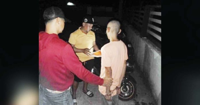 Officers of the Pavia Municipal Police Station led by Major Harold Rendora serve the arrest warrant for robbery with violence against or intimidation of persons, or Revised Penal Code Article 294, against Ronald Arguilles Fajardo (right) in San Jose City, Nueva Ecija on Oct. 31, 2024. PAVIA MUNICIPAL POLICE STATION PHOTO