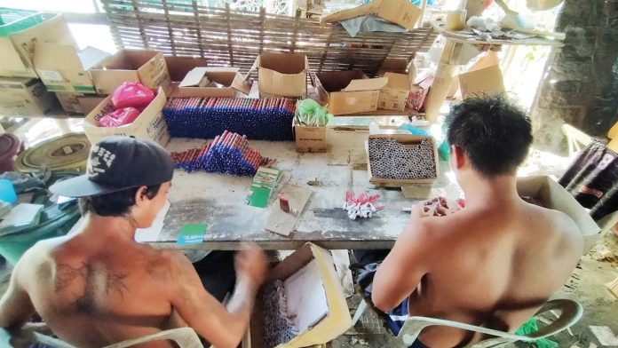 Young men make f irecrackers somewhere in Iloilo City’s Arevalo district which is traditionally deemed the “firecracker capital” of Iloilo. The Department of Health in Western Visayas is discouraging people from setting off f irecrackers to celebrate the holidays, calling it a hazardous practice.