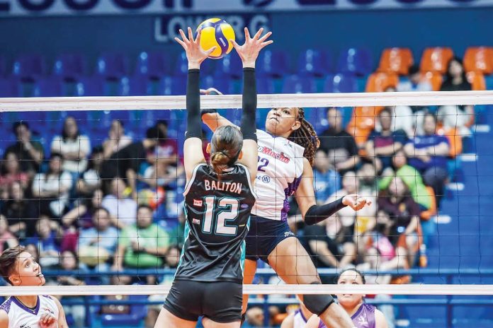 Choco Mucho Flying Titans’ Cherry Nunag smashes the ball against the defense of Galeries Tower Highrisers’ Roselle Baliton. PVL PHOTO