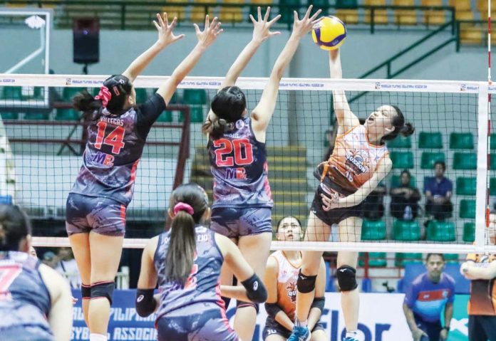 Quezon Tangerines’ Mary Grace Borromeo smashes the ball against two Biñan Tatak Gel 1-Pacman Partylist Volley Angels’ defenders. MPVA PHOTO