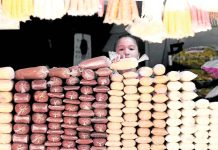 A woman stacks sugar at a store in Manila. The Sugar Regulatory Administration estimated about 200,000 to 300,000 metric tons of “other sugar” products were coming to the country per year. INQUIRER/ MARIANNE BERMUDEZ