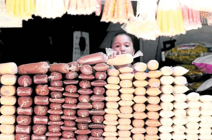 A woman stacks sugar at a store in Manila. The Sugar Regulatory Administration estimated about 200,000 to 300,000 metric tons of “other sugar” products were coming to the country per year. INQUIRER/ MARIANNE BERMUDEZ