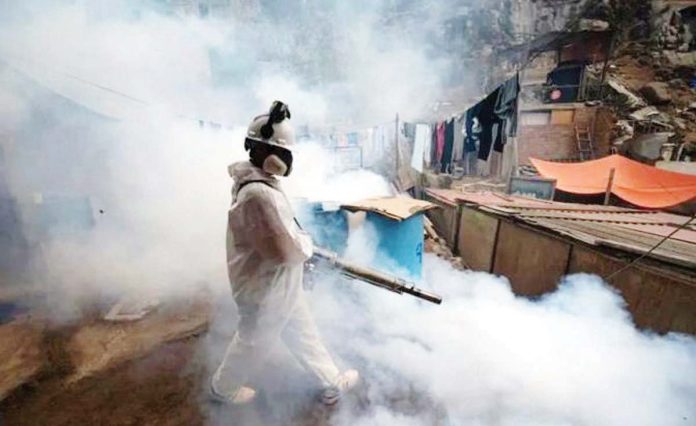 A member of a health brigade fumigates a street against the dengue virus in Lima, Peru. GETTY IMAGES