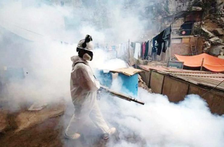 A member of a health brigade fumigates a street against the dengue virus in Lima, Peru. GETTY IMAGES