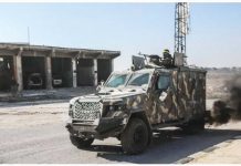 Rebel fighters led by Hayat Tahrir al-Sham (HTS) drive an armored vehicle during an offensive against government forces in north-western Syria. ANADOLU