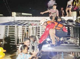 Residents of Sagrado Villas housing site in Barangay Burgos, Cadiz City, Negros Occidental were being rescued by a volunteer of the Philippine Red Cross Negros Occidental-Bacolod City Chapter early Monday morning, Dec. 23, 2024. Torrential rains caused by shearline affecting the Visayas brought flash floods in Cadiz City and the neighboring Manapla town and Victorias City on Sunday night, Dec 22. PRC NEGROS OCCIDENTAL-BACOLOD CITY CHAPTER PHOTO