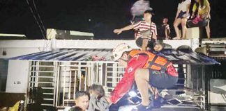 Residents of Sagrado Villas housing site in Barangay Burgos, Cadiz City, Negros Occidental were being rescued by a volunteer of the Philippine Red Cross Negros Occidental-Bacolod City Chapter early Monday morning, Dec. 23, 2024. Torrential rains caused by shearline affecting the Visayas brought flash floods in Cadiz City and the neighboring Manapla town and Victorias City on Sunday night, Dec 22. PRC NEGROS OCCIDENTAL-BACOLOD CITY CHAPTER PHOTO