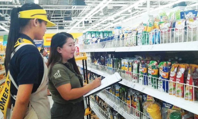 An inspector from the Department of Trade and Industry checks the prices of noche buena products at a supermarket in Iloilo City. DTI REGION 6 PHOTO