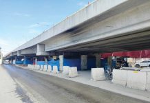 Safety barriers and protective coverings surround the repair site of the Ungka Flyover in Pavia, Iloilo, as concerns over falling debris prompt calls for tighter safety measures. The Department of Public Works and Highways - Region 6 is being urged to ensure public safety during the repair process. IME SORNITO/PN