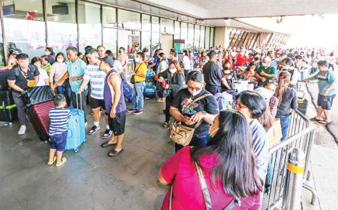 Hundreds of stranded passengers crowd the Ninoy Aquino International Airport Terminal 1 in Pasay City after hundreds of flights were cancelled, delayed or diverted on New Year's Day, Jan. 1, 2023. “Technical issues” at the air navigation facilities of the Civil Aviation Authority of the Philippines prompted the cancellation of local and international flights, according to the Department of Transportation. GERARD CARREON PHOTO