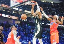 Giannis Antetokounmpo of Milwaukee Bucks dunks ahead of Shai Gilgeous-Alexander of Oklahoma City Thunder. GETTY IMAGES