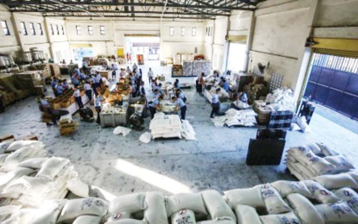 Volunteers and staff of the Department of Social Welfare and Development help prepare family food packs at the National Resource Operation Center. DSWD is mulling to set up a warehouse in every municipality in Western Visayas. PNA PHOTO BY JOAN BONDOC