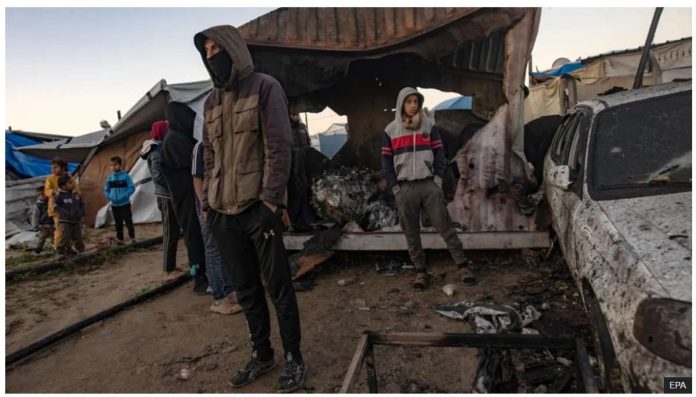 People inspect damage after an Israeli air strike reportedly killed 11 people at a tent camp for displaced families in al-Mawasi, southern Gaza. Israel has attacked heavily populated areas, saying Hamas militants hide among displaced civilians. EPA