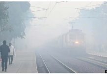 Commuters walk on railway tracks wearing caps and jackets as a train arrives amid fog at Shahabad Mohammadpur railway station in the morning winter chill and fog in New Delhi, India. Dozens of flights and trains have been delayed due to bad weather conditions. GETTY IMAGES