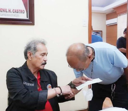 Gov. Fredenil Castro (left) hands the check worth P100,000 intended as aid to the family of one of the two overseas Filipino workers from Capiz who perished in a fire in Kuwait on Dec. 2, 2024. CAPIZ PROV’L GOV’T COMMUNICATIONS GROUP/FB PHOTO