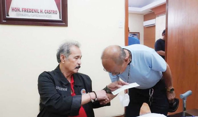 Gov. Fredenil Castro (left) hands the check worth P100,000 intended as aid to the family of one of the two overseas Filipino workers from Capiz who perished in a fire in Kuwait on Dec. 2, 2024. CAPIZ PROV’L GOV’T COMMUNICATIONS GROUP/FB PHOTO