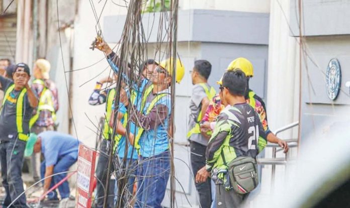 The City Engineer’s Office initiated the dismantling of the remaining lines and poles along JM Basa Street in Iloilo City as part of the underground cabling project of the city government. JERRY TREÑAS/FACEBOOK PHOTOS