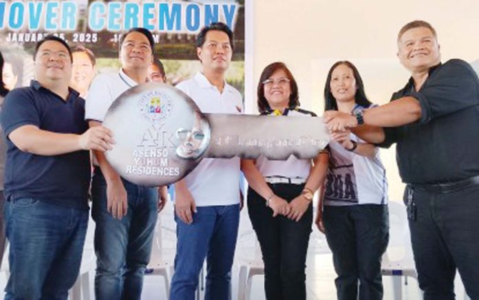 Bacolod City’s Mayor Alfredo Abelardo Benitez (third from left), other local officials and Pag-IBIG Fund representatives hand over the symbolic key to the Asenso Yuhum Residences in Barangay Vista Alegre to Emmanuel Villaera, president of the Building 1 Homeowners Association, on Saturday, Jan. 25, 2025. PNA PHOTO NANETTE L. GUADALQUIVER