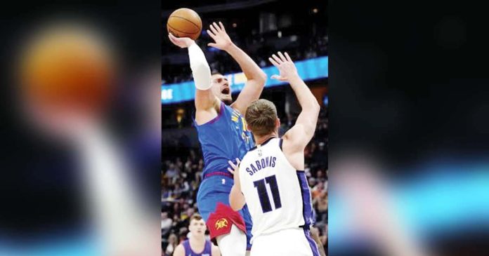 Denver Nuggets’ Nikola Jokic scores over the defense of Sacramento Kings' Domantas Sabonis. AP PHOTO