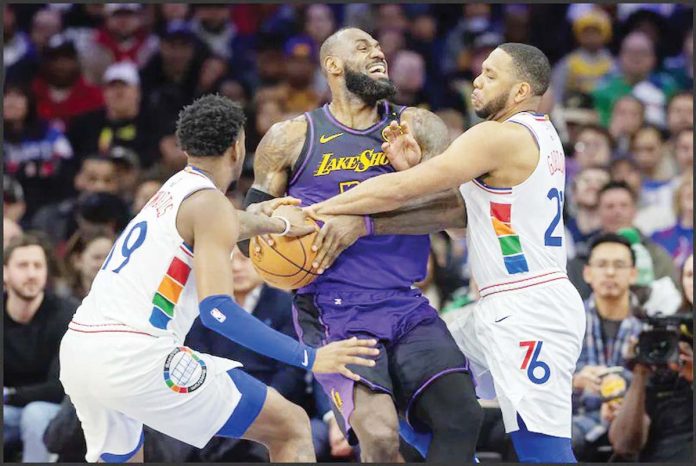 PHILADELPHIA 76ers’ Justin Edwards and Eric Gordon converge upon LeBron James of Los Angeles Lakers during the first half of their game. Photo courtesy of Charles Fox/The Inquirer