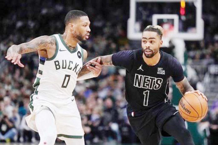 Brooklyn Nets guard D’Angelo Russell tries to get past the defense of Milwaukee Bucks guard Damian Lillard. AP PHOTO/MORRY GASH