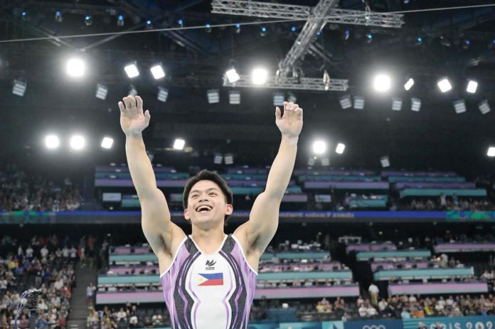 Filipino gymnast Carlos Edriel Yulo raises his arms after winning the vault event of the 2024 Paris Olympics. FIG