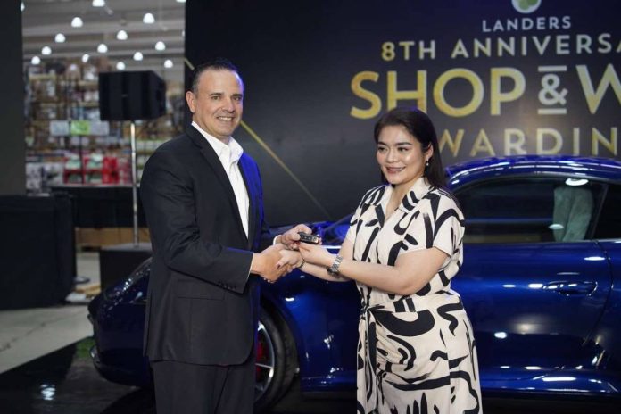 Landers Superstore Chief Transformation Officer Bill Cummings turns over the key to a brand-new Porsche 911 Carrera S to Ms. Ingrid Rose Panuncialman, a lucky winner from Landers Alabang, during the Grand Shop & Win Raffle Awarding Ceremony.