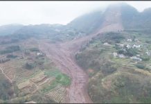 An aerial shot shows the damage after a landslide in south-western China. A large brown slash of mud and rock cuts through the otherwise green landscape in Jinping village in Sichuan province. XINHUA/AP