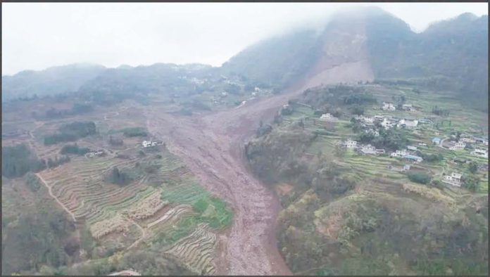 An aerial shot shows the damage after a landslide in south-western China. A large brown slash of mud and rock cuts through the otherwise green landscape in Jinping village in Sichuan province. XINHUA/AP