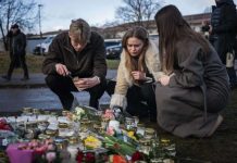 Swedes pay their respects to victims of a school shooting by lighting candles and offering flowers. Police say the gunman legally owned four rifles, three of which were found at the crime scene. GETTY IMAGES