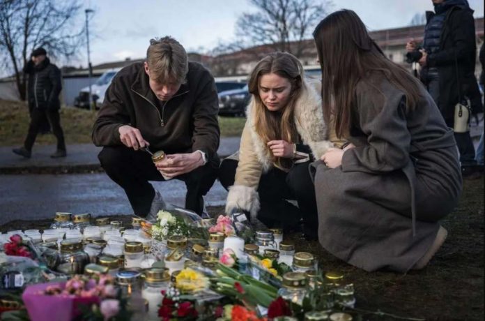 Swedes pay their respects to victims of a school shooting by lighting candles and offering flowers. Police say the gunman legally owned four rifles, three of which were found at the crime scene. GETTY IMAGES