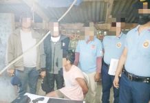 Alias “Bebot” (sitting) was caught with suspected shabu and a 12-gauge shotgun in a raid in Calinog, Iloilo on Monday morning, Feb. 10, 2025. CALINOG MUNICIPAL POLICE STATION PHOTO