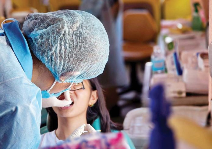 A dentist from the Iloilo Provincial Health Office (IPHO) attends to a child’s dental care in Carles, Iloilo, in November 2024. PHOTO COURTESY OF IPHO FACEBOOK PAGE