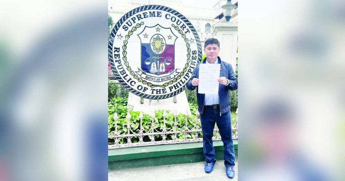 Former Iloilo City councilor Plaridel Nava II stands outside the Supreme Court, holding a copy of his petition challenging the executive clemency granted to former mayor Jed Patrick Mabilog.