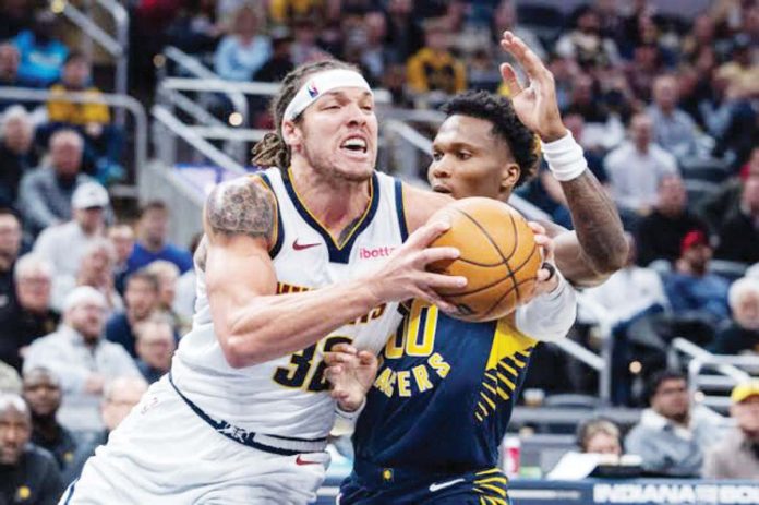 Denver Nuggets’ Aaron Gordon (32) holds on the ball while being defended by Indiana Pacers’ Bennedict Mathurin (00). Photo: TREVOR RUSZKOWSKI-IMAGN IMAGES