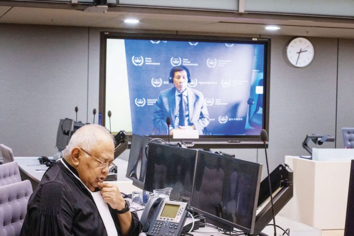 Former President Rodrigo Duterte makes his first appearance at the International Criminal Court via video link in The Hague, Netherlands. In this pre-trial hearing, the judges verified his identity, informed him of the charges against him, and enumerated his rights. Also in photo is Salvador Medialdea, his executive secretary during his term. INQUIRER.NET